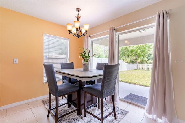 12624 White Bluff Rd, Hudson, FL 34669 - dining space featuring a chandelier, light tile patterned floors, and baseboards