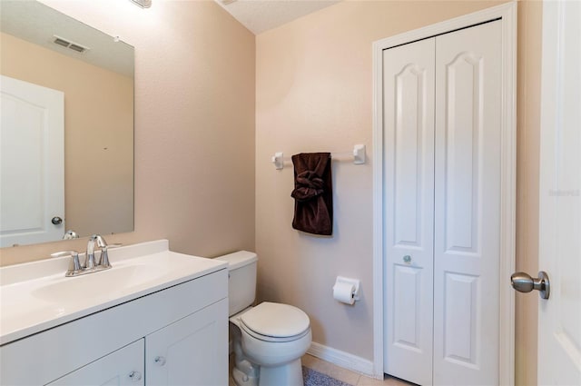 12624 White Bluff Rd, Hudson, FL 34669 - bathroom featuring vanity, toilet, tile patterned flooring, a closet, and baseboards
