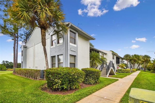 1967 Cormorant Ct Unit 515, Clearwater, FL 33762 - view of side of home with stucco siding and a lawn