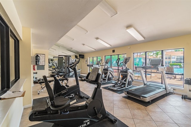 1967 Cormorant Ct Unit 515, Clearwater, FL 33762 - workout area featuring healthy amount of natural light, light tile patterned flooring, and baseboards