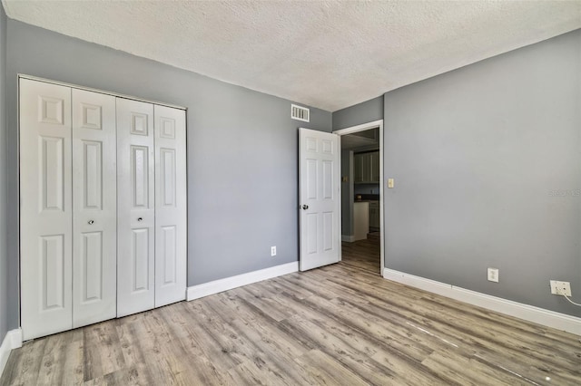 1967 Cormorant Ct Unit 515, Clearwater, FL 33762 - unfurnished bedroom with wood finished floors, a textured ceiling, baseboards, and a closet