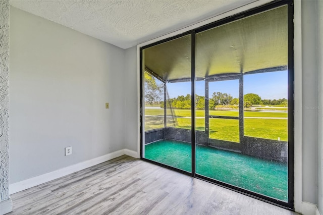 1967 Cormorant Ct Unit 515, Clearwater, FL 33762 - empty room featuring wood finished floors, a textured ceiling, baseboards, and view of golf course