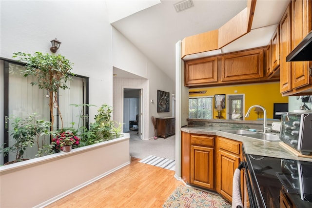 70 Morning Dove Pl, Oldsmar, FL 34677 - kitchen featuring brown cabinetry, light wood finished floors, black electric range, light countertops, and high vaulted ceiling