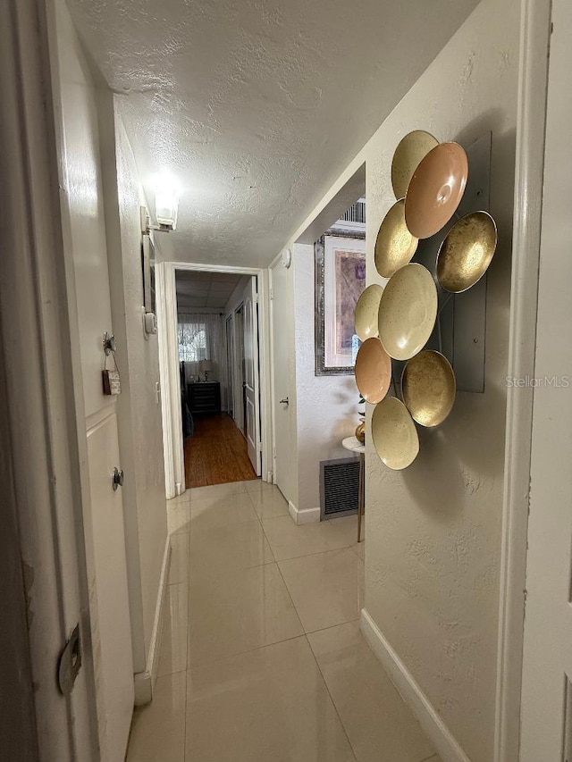 5860 43rd Ter N Unit 1518, Kenneth City, FL 33709 - hallway with baseboards, a textured ceiling, a textured wall, and tile patterned flooring