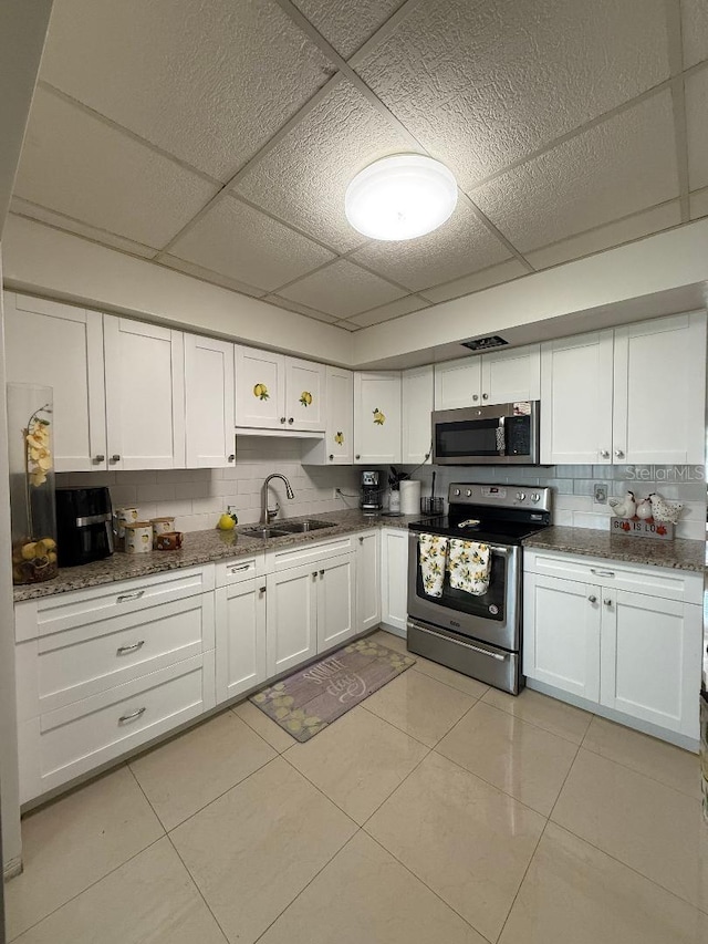 5860 43rd Ter N Unit 1518, Kenneth City, FL 33709 - kitchen featuring stainless steel appliances, a sink, a paneled ceiling, tasteful backsplash, and white cabinets