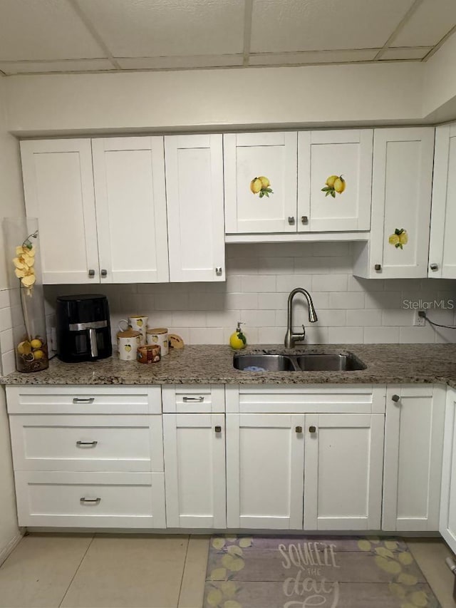 5860 43rd Ter N Unit 1518, Kenneth City, FL 33709 - kitchen with a sink, white cabinets, stone countertops, and decorative backsplash