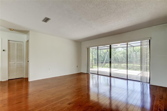 50 Ingrid Pl Unit 50, Oldsmar, FL 34677 - spare room with a textured ceiling and hardwood / wood-style floors