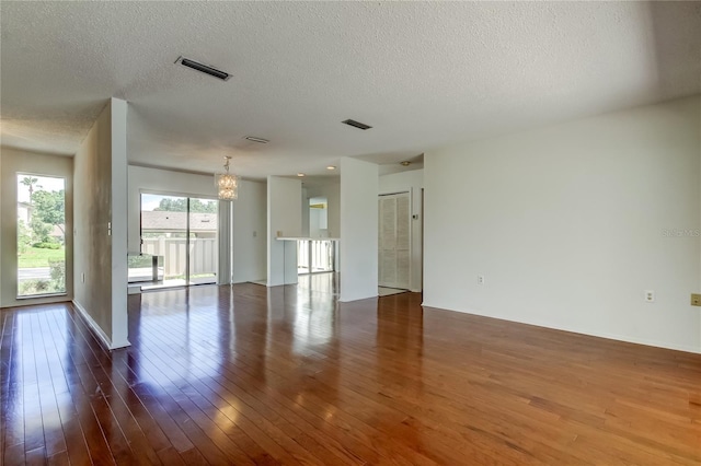 50 Ingrid Pl Unit 50, Oldsmar, FL 34677 - unfurnished room featuring a chandelier, hardwood / wood-style floors, and a textured ceiling