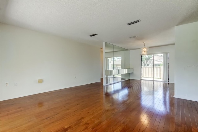 50 Ingrid Pl Unit 50, Oldsmar, FL 34677 - spare room featuring wood-type flooring, a textured ceiling, and a chandelier