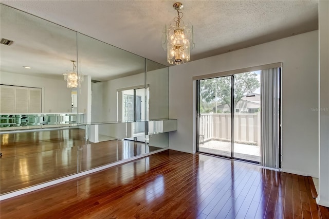 50 Ingrid Pl Unit 50, Oldsmar, FL 34677 - empty room featuring a chandelier, hardwood / wood-style floors, and a textured ceiling