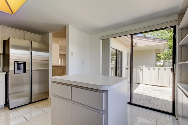 50 Ingrid Pl Unit 50, Oldsmar, FL 34677 - kitchen featuring stainless steel refrigerator with ice dispenser, light tile patterned flooring, light countertops, and a kitchen island