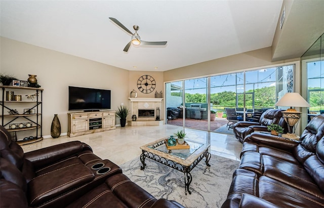 1710 Lago Vista Blvd, Palm Harbor, FL 34685 - living room featuring a ceiling fan, plenty of natural light, marble tiled floors, and a tile fireplace
