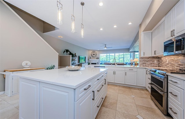 1710 Lago Vista Blvd, Palm Harbor, FL 34685 - kitchen with appliances with stainless steel finishes, a ceiling fan, a center island, decorative backsplash, and recessed lighting