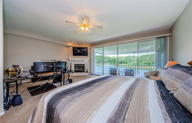 1710 Lago Vista Blvd, Palm Harbor, FL 34685 - bedroom featuring access to exterior, a desk, a tile fireplace, and a ceiling fan
