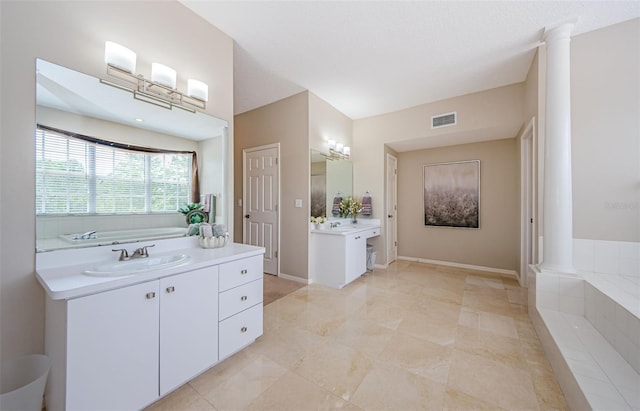 1710 Lago Vista Blvd, Palm Harbor, FL 34685 - bathroom with ornate columns, two vanities, and a bath