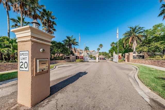 1710 Lago Vista Blvd, Palm Harbor, FL 34685 - view of asphalt street featuring street lighting, curbs, a gated entry, and a residential view