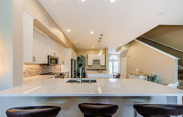 1710 Lago Vista Blvd, Palm Harbor, FL 34685 - kitchen featuring stainless steel appliances, a peninsula, backsplash, recessed lighting, and white cabinetry