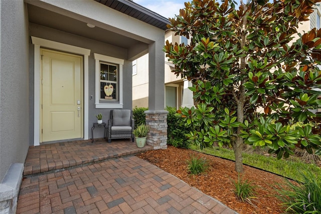 4077 Cadence Loop, Land O Lakes, FL 34638 - view of exterior entry featuring stucco siding and covered porch