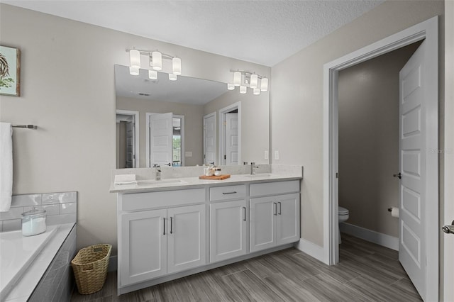4077 Cadence Loop, Land O Lakes, FL 34638 - full bath with double vanity, toilet, tiled tub, wood finished floors, and baseboards