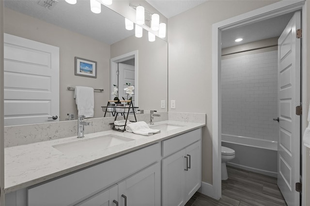 4077 Cadence Loop, Land O Lakes, FL 34638 - bathroom featuring double vanity, toilet, wood finished floors, and tub / shower combination