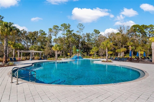 4077 Cadence Loop, Land O Lakes, FL 34638 - community pool with a pergola, a water slide, a patio, and view of wooded area