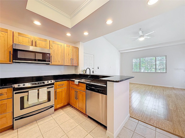2015 SE 10th Ave Unit 123, Fort Lauderdale, FL 33316 - kitchen with stainless steel appliances, a peninsula, ornamental molding, recessed lighting, and dark countertops