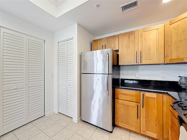 2015 SE 10th Ave Unit 123, Fort Lauderdale, FL 33316 - kitchen featuring freestanding refrigerator, light tile patterned floors, dark countertops, and stove
