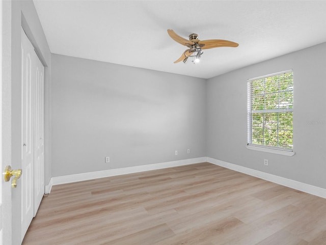 8806 Bayaud Dr, Tampa, FL 33626 - unfurnished bedroom with light wood finished floors, baseboards, a closet, and a ceiling fan