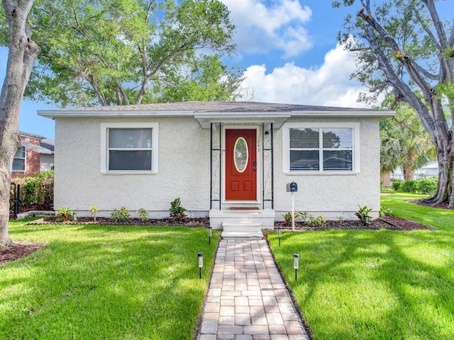 1243 55th Ave N, Saint Petersburg, FL 33703 - view of front facade featuring stucco siding and a front lawn