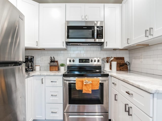 1243 55th Ave N, Saint Petersburg, FL 33703 - kitchen featuring stainless steel appliances, white cabinetry, backsplash, and light stone counters
