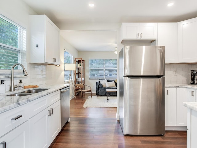 1243 55th Ave N, Saint Petersburg, FL 33703 - kitchen featuring appliances with stainless steel finishes, decorative backsplash, recessed lighting, dark wood finished floors, and light stone countertops