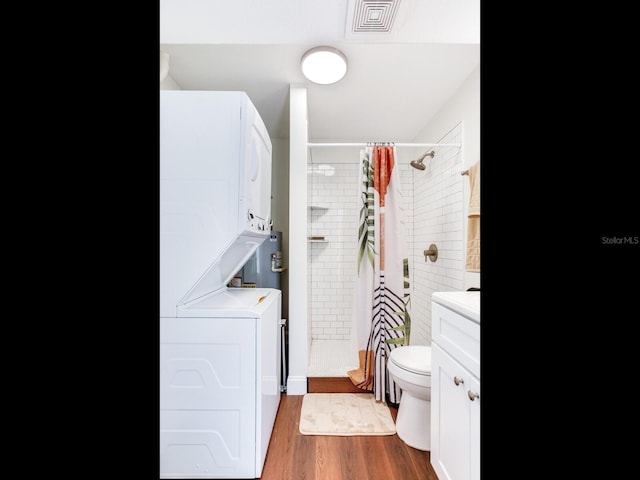 1243 55th Ave N, Saint Petersburg, FL 33703 - bathroom with stacked washing machine and dryer, a shower stall, vanity, and wood finished floors