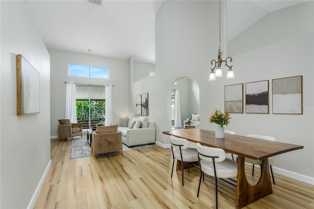 12335 Glenfield Ave, Tampa, FL 33626 - dining area with arched walkways, high vaulted ceiling, light wood-style floors, baseboards, and a chandelier