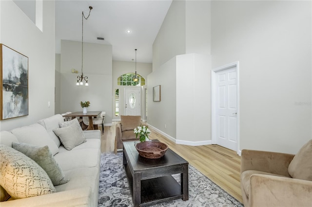 12335 Glenfield Ave, Tampa, FL 33626 - living area with high vaulted ceiling, light wood-style flooring, baseboards, and a chandelier