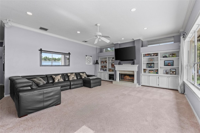 15012 Maurine Cove Ln, Odessa, FL 33556 - living area with light colored carpet, ornamental molding, recessed lighting, a tiled fireplace, and a ceiling fan
