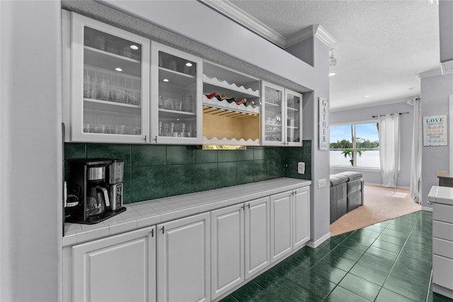 15012 Maurine Cove Ln, Odessa, FL 33556 - bar featuring ornamental molding, tasteful backsplash, a textured ceiling, dark tile patterned flooring, and dark colored carpet