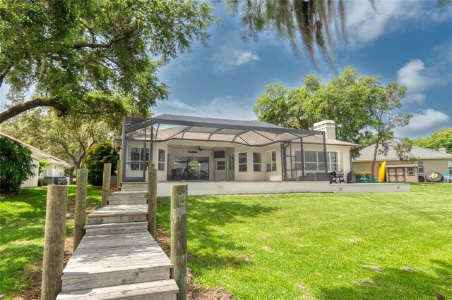 15012 Maurine Cove Ln, Odessa, FL 33556 - rear view of property with ceiling fan, a chimney, a lawn, glass enclosure, and a patio area