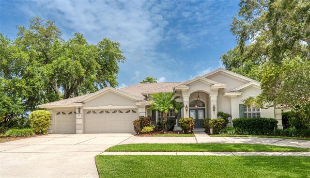 15012 Maurine Cove Ln, Odessa, FL 33556 - view of front of property with french doors, a garage, stucco siding, and concrete driveway