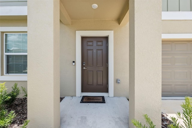 34797 Rainville Loop, Zephyrhills, FL 33541 - doorway to property featuring stucco siding and a garage