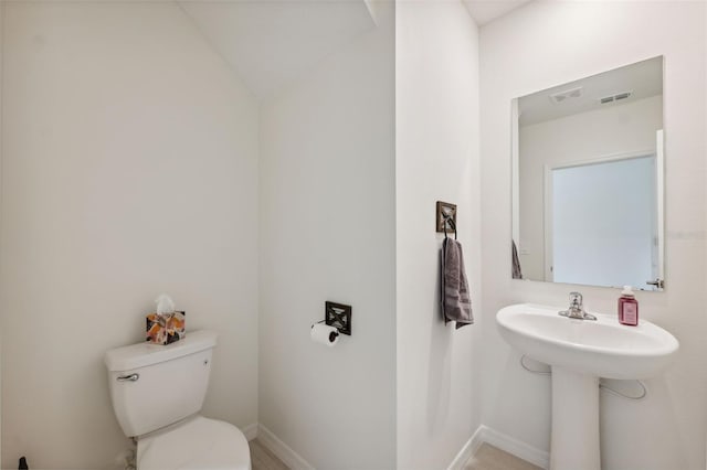 34797 Rainville Loop, Zephyrhills, FL 33541 - half bath featuring toilet, baseboards, vaulted ceiling, and a sink