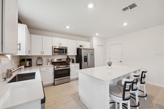 34797 Rainville Loop, Zephyrhills, FL 33541 - kitchen featuring appliances with stainless steel finishes, a sink, a kitchen breakfast bar, a center island, and light countertops