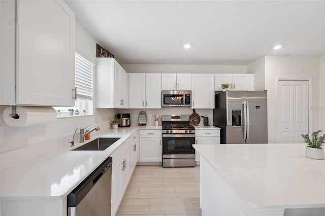 34797 Rainville Loop, Zephyrhills, FL 33541 - kitchen featuring appliances with stainless steel finishes, a sink, white cabinets, light countertops, and recessed lighting