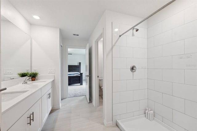 34797 Rainville Loop, Zephyrhills, FL 33541 - full bathroom with double vanity, a tile shower, toilet, and baseboards