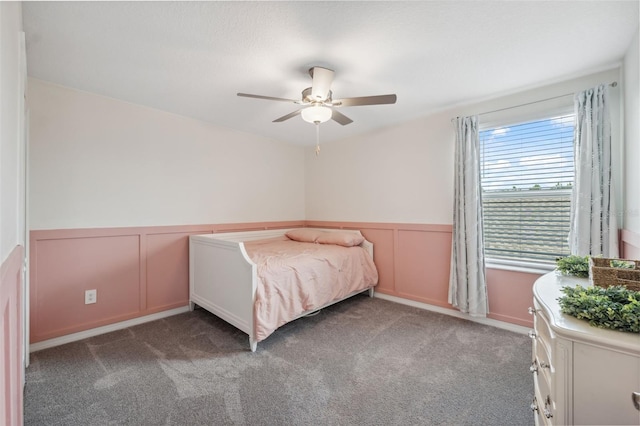 34797 Rainville Loop, Zephyrhills, FL 33541 - carpeted bedroom featuring a wainscoted wall, a decorative wall, and a ceiling fan