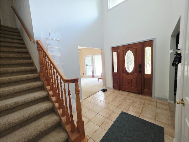 2975 E Withlacoochee Trl, Dunnellon, FL 34434 - entryway featuring stairs, a towering ceiling, light tile patterned floors, plenty of natural light, and light carpet