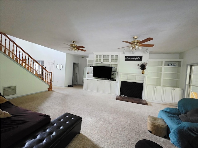 2975 E Withlacoochee Trl, Dunnellon, FL 34434 - living room with ceiling fan, stairs, a fireplace, and light colored carpet