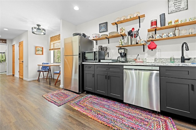 7013 W Polaris Ct, Homosassa, FL 34446 - kitchen featuring appliances with stainless steel finishes, wood finished floors, gray cabinetry, light stone counters, and recessed lighting