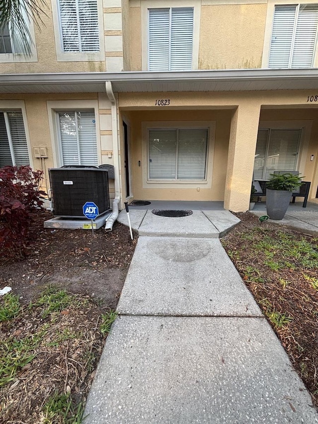 10823 Brickside Ct, Riverview, FL 33579 - doorway to property featuring cooling unit and stucco siding