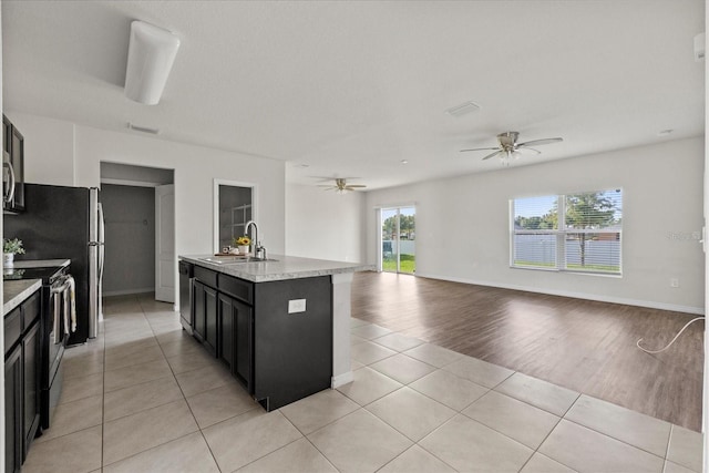 14403 Dunrobin Dr, Wimauma, FL 33598 - kitchen featuring a sink, stainless steel appliances, open floor plan, ceiling fan, and light tile patterned floors