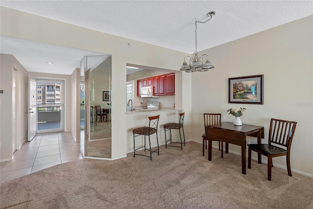 7932 Sailboat Key Blvd S Unit 406, South Pasadena, FL 33707 - dining space featuring a chandelier, light colored carpet, a textured ceiling, and light tile patterned floors